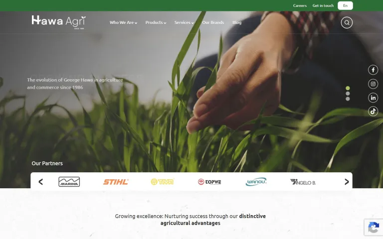 Hawa Agri homepage on desktop, with a full-width photo of a hand touching young crops, the main navigation, and a carousel of partner brand logos